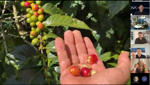 Honduran coffee farmer shows fruit and coffee beans at Charles IT vendor summit coffee tasting event. 